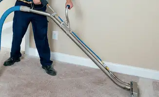 Professional operating a liquid removal machine on a carpeted floor in Oakland, CA